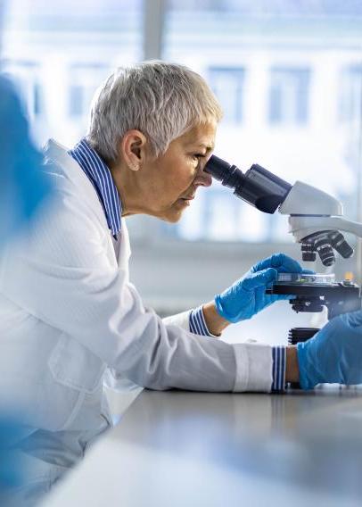 Chemist working on a microscope in laboratory